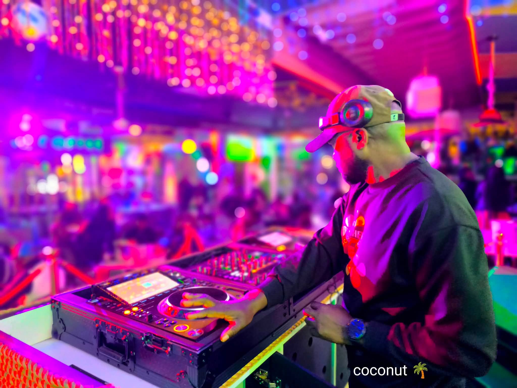 DJ under the lights with the full lounge behind him